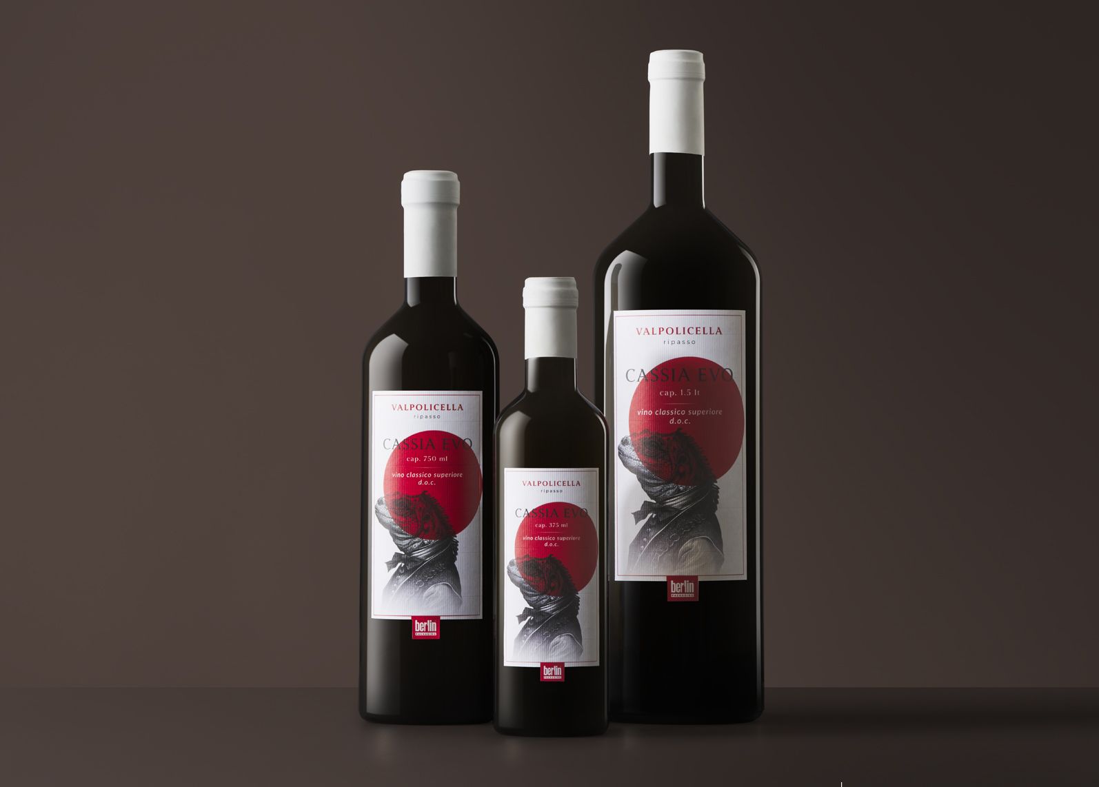 Three Cassia Evo bottles from wine collection with white caps, labeled and against a dark background.