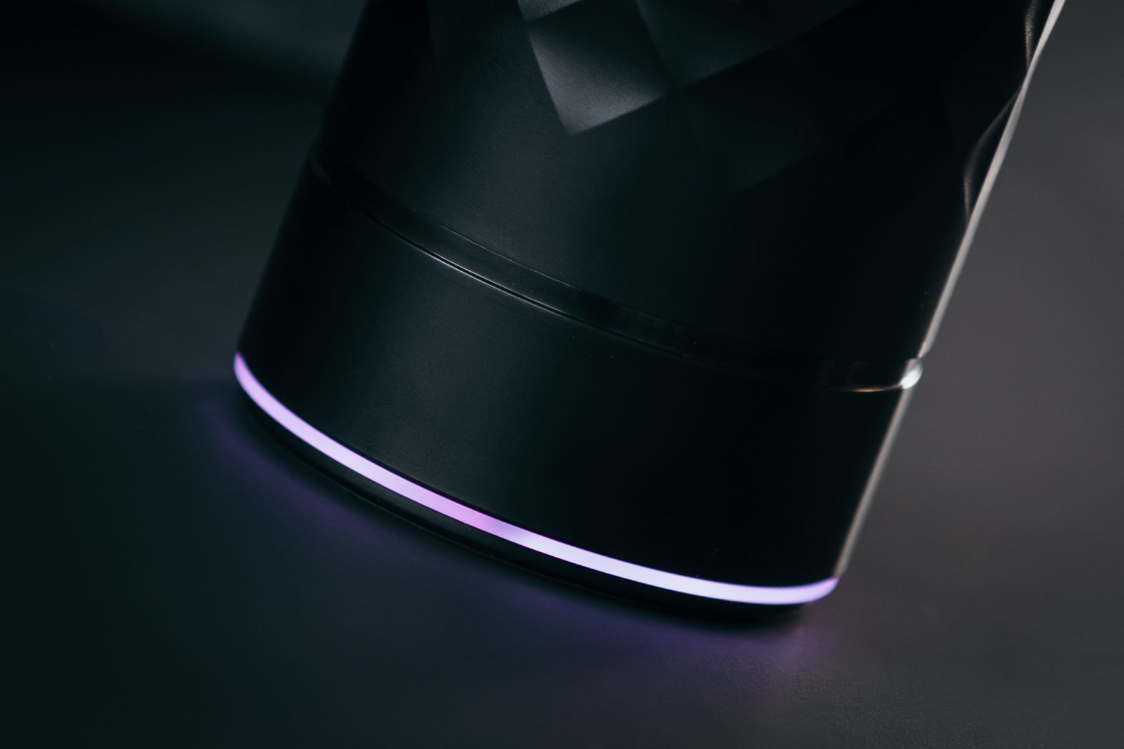 Plain Text Ininum smart fragrance device by Berlin Packaging Beauty, close-up of the illuminated LED base integrated into the faceted black design, enhancing the user experience of the connected fragrance system.