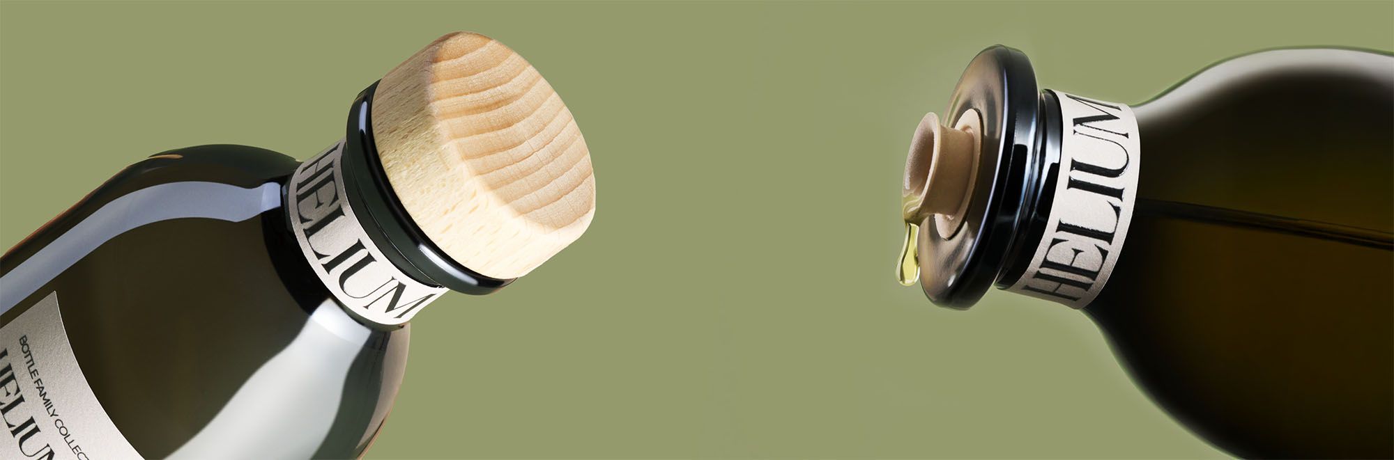 Close-up of Helium extra virgin olive oil pouring from a dark glass bottle with sustainable wooden cap on a green background.