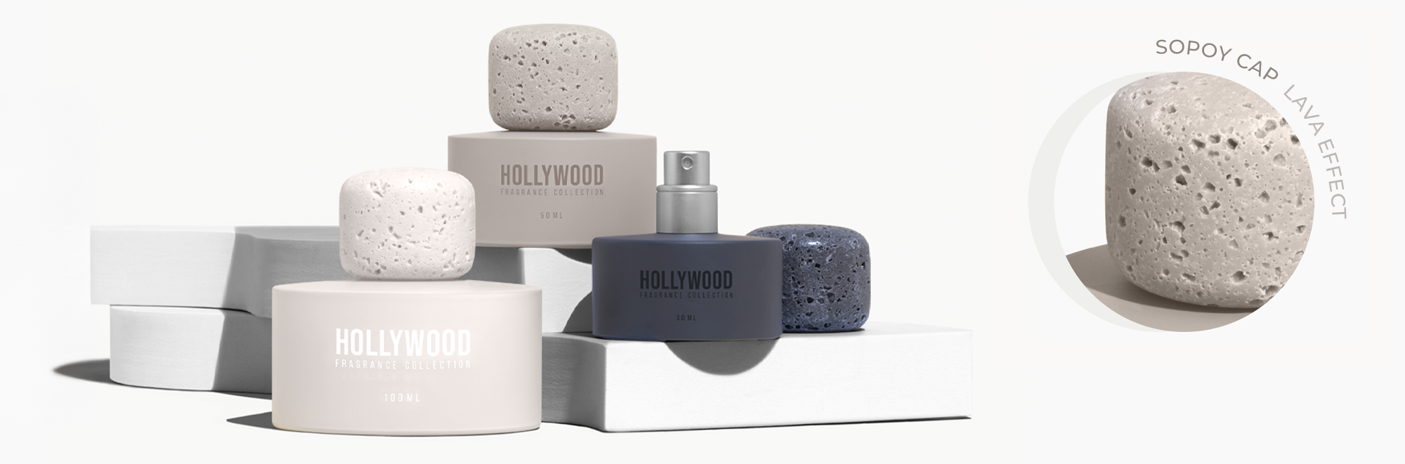 BP_EM_INTERNATIONAL_NEWS_HOLLYWOOD_FOCUS CAP Hollywood Fragrance Collection bottles in neutral tones with volcanic stone-style caps, arranged on white blocks. Includes close-up of textured cap. Elegant luxury perfume packaging.