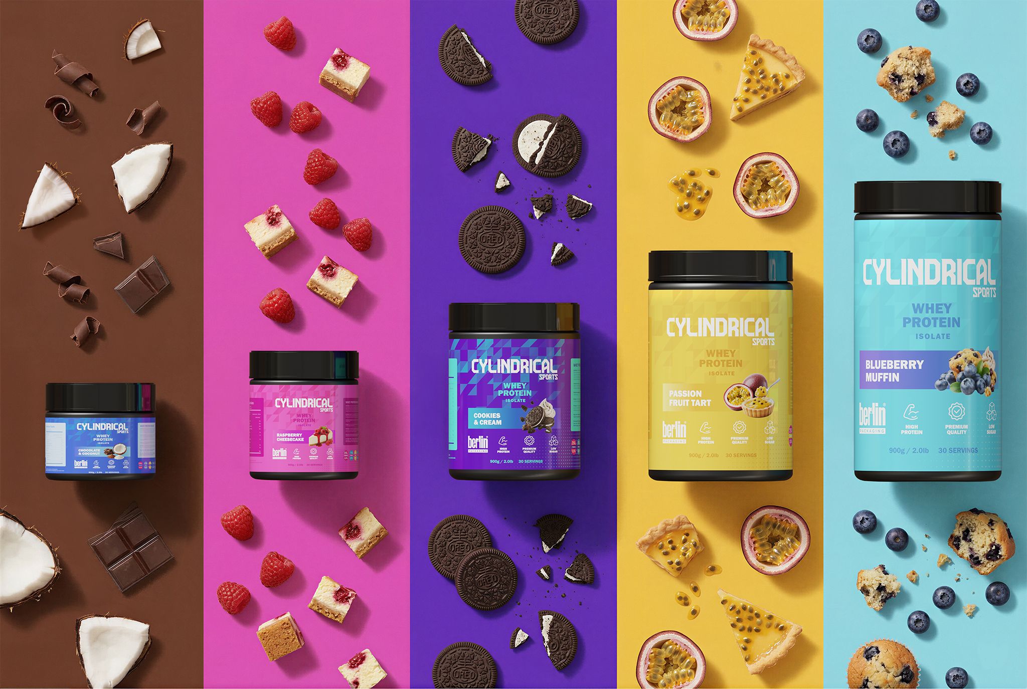Top‑down view of Cylindrical whey protein tubs displayed on colorful vertical backgrounds, each paired with matching flavor ingredients such as chocolate pieces, coconut, raspberries, cookie crumbs, passion fruit, and blueberry muffins, creating a vibrant, flavor‑coded composition.