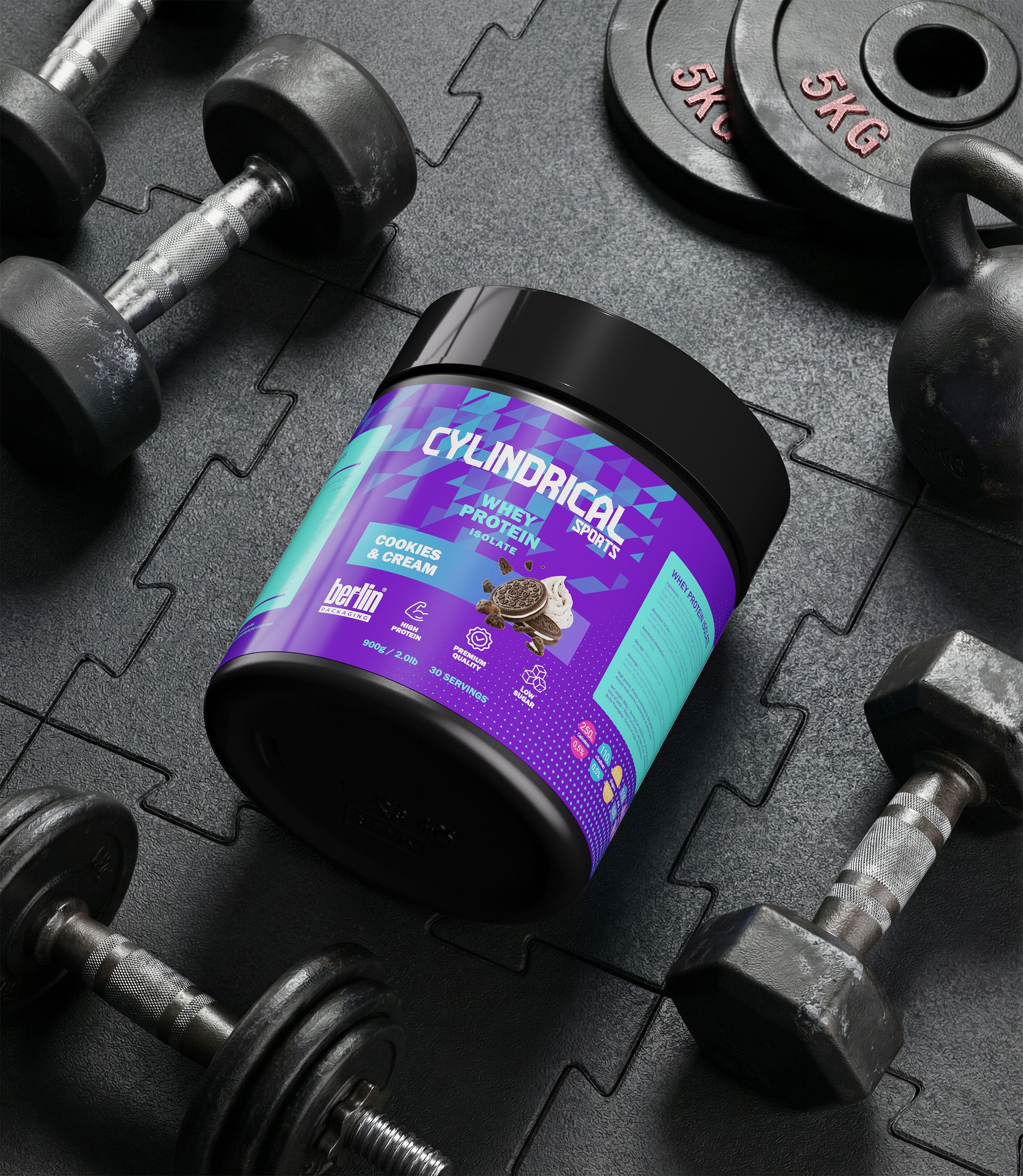 Cylindrical whey protein tub in Cookies & Cream flavor placed on a rubber gym floor, surrounded by dumbbells and weight plates in a training environment.
