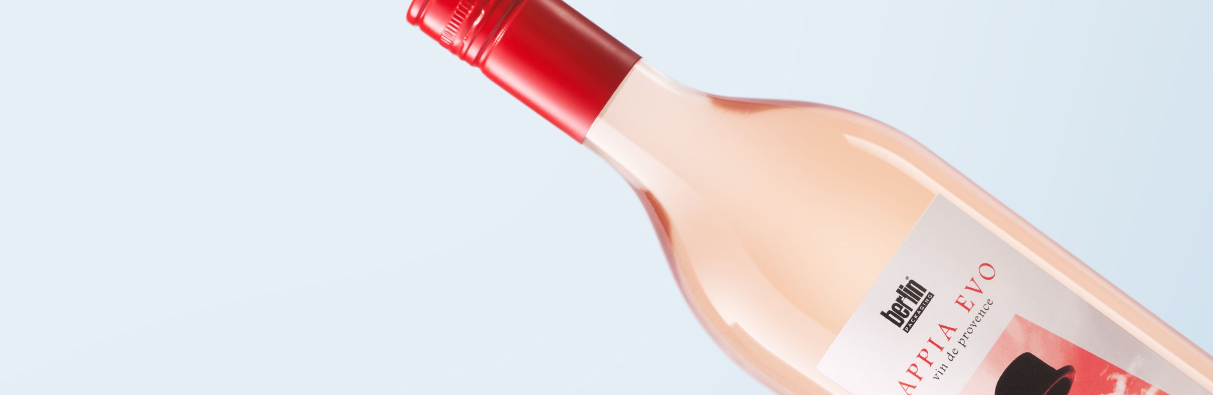Appia Evo bottle for rosè wine with a red cap and a label  set against a light blue background.