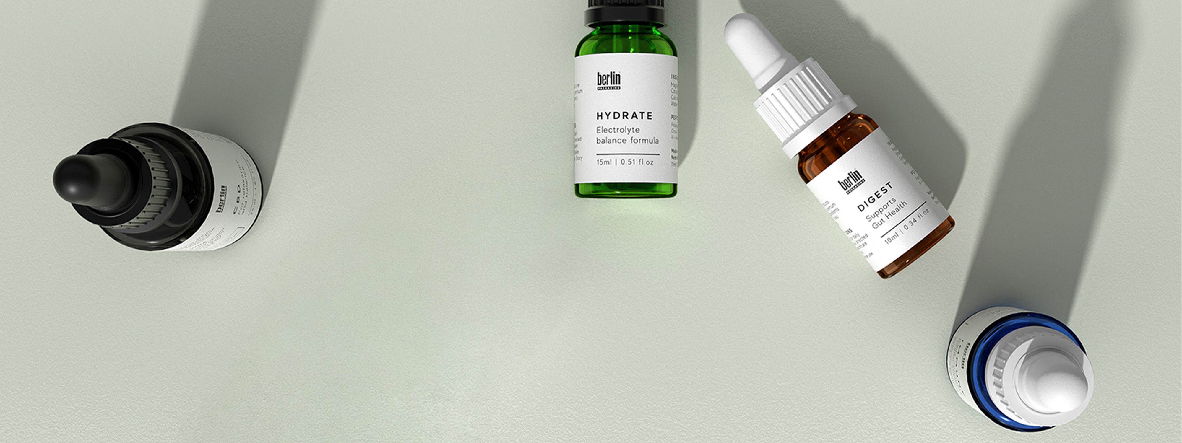 Various dropper bottles with labels for skincare and health products arranged on a light surface.