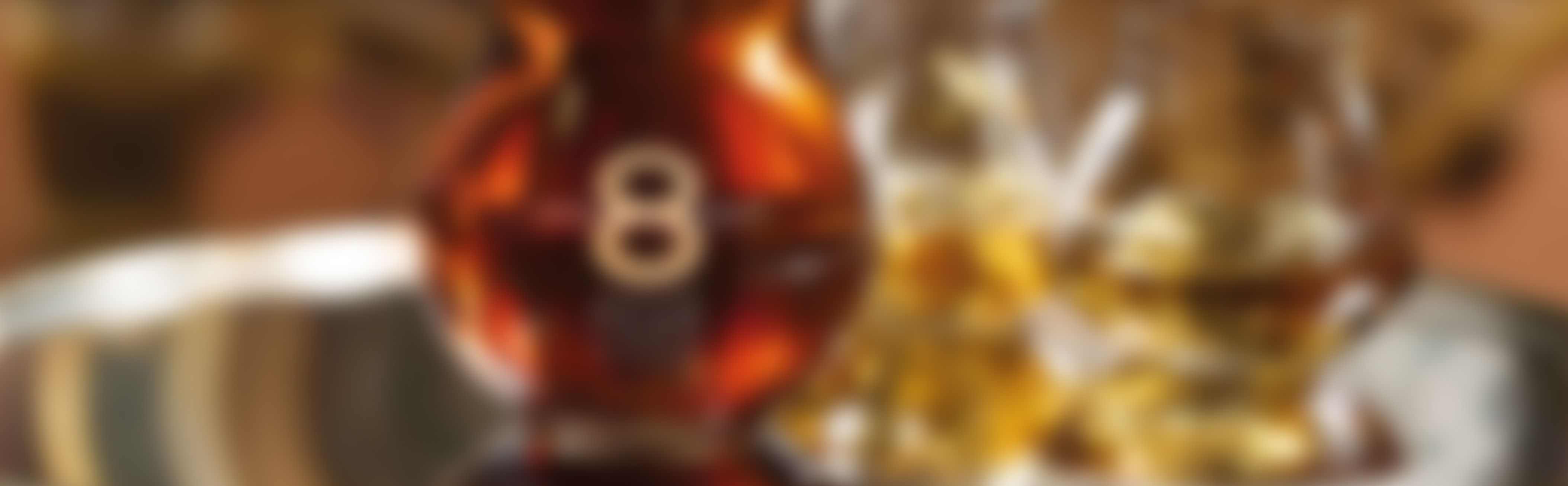 Custom‑designed premium spirits bottle with a golden amber hue and a large number 8 on the label, shown in a warm and elegant bar setting.