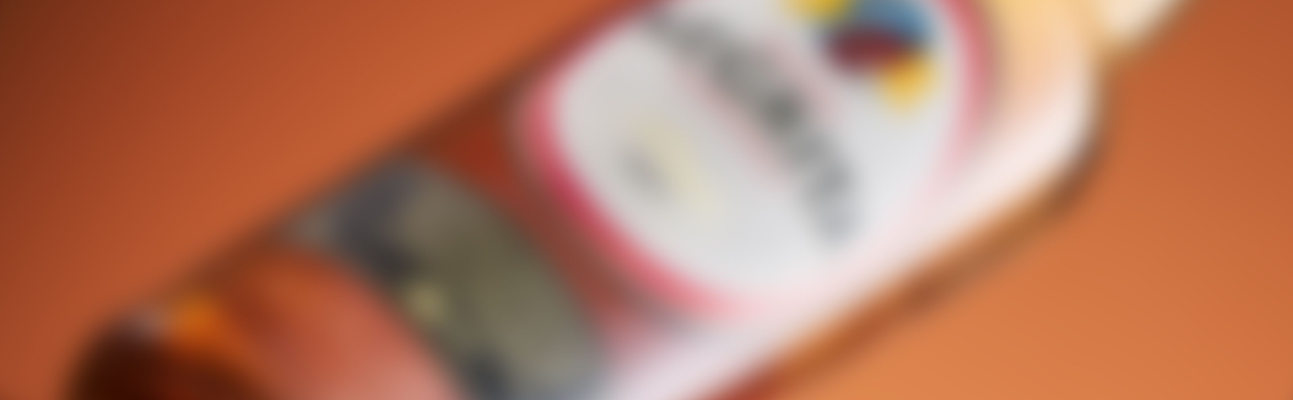 A blurred image of Bardinet negrita rhum bottle with a red and white label against an orange background.