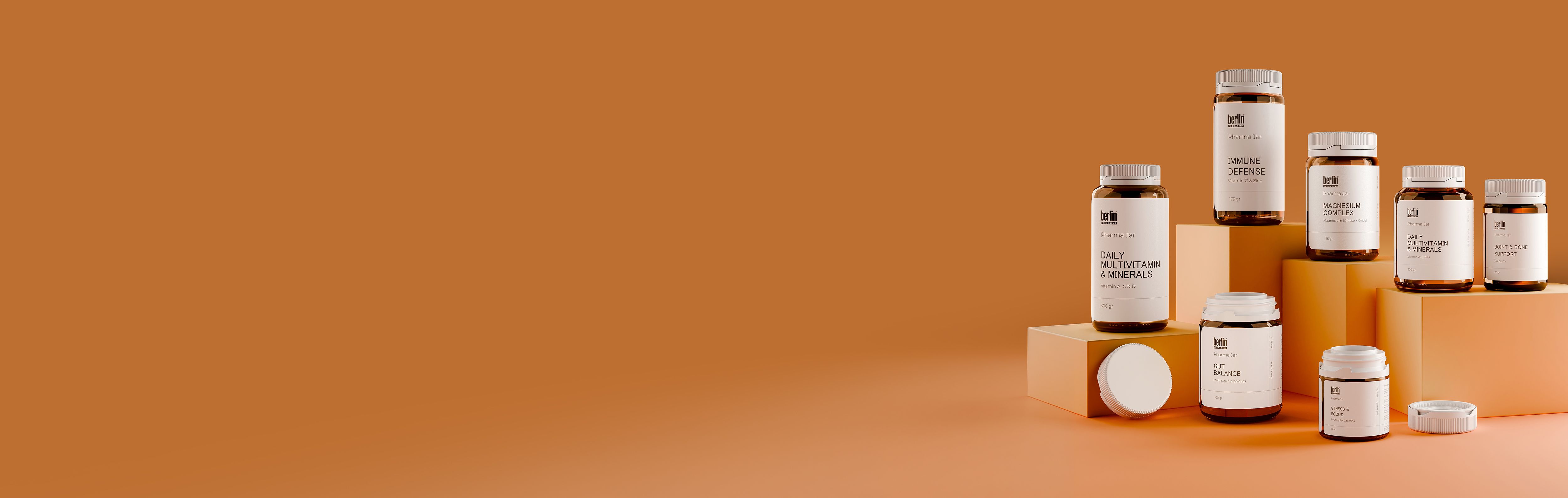 Glass Pharma Jars 1 Brown glass supplement jars displayed on geometric pedestals against an orange background, featuring labels like "Daily Multivitamin" and "Immune Defense."