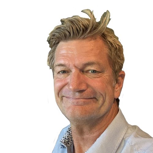 Bjarke Smiling man with styled hair wearing a light blue collared shirt against a plain white background.