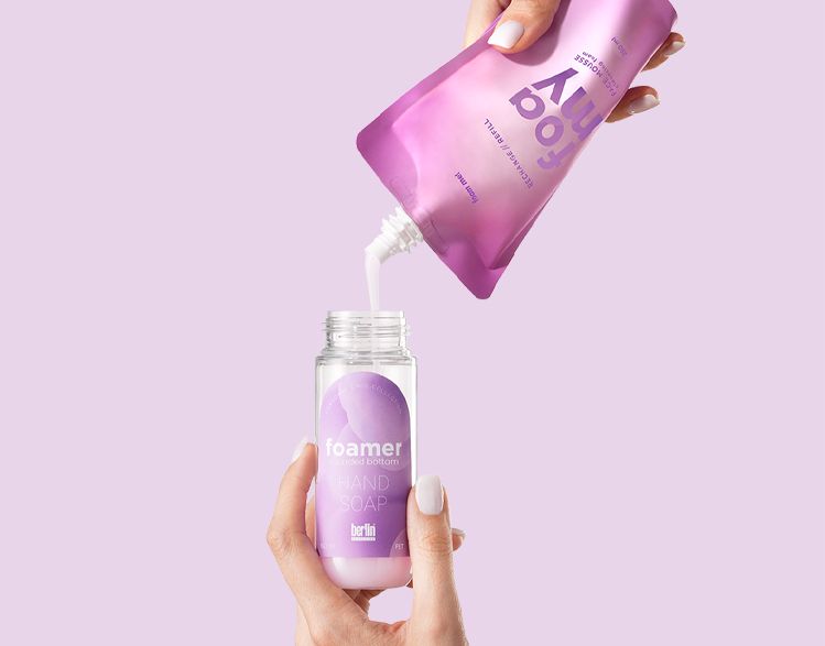 Foamer Rounded Bottom by Berlin Packaging Beauty, refill pouch pouring liquid into reusable foamer bottle, highlighting sustainable refill system and eco-friendly hand soap packaging.