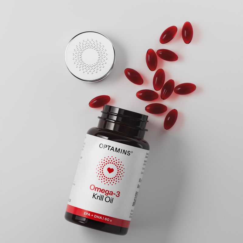 Bottle of Omega-3 Krill Oil capsules with red softgels scattered beside it, against a neutral background.