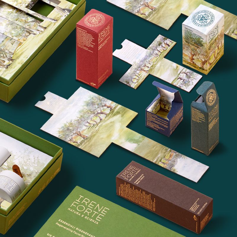 Coordinated secondary packaging for Irene Forte Skincare, showing folding boxes and rigid boxes with illustrated interiors and refined materials