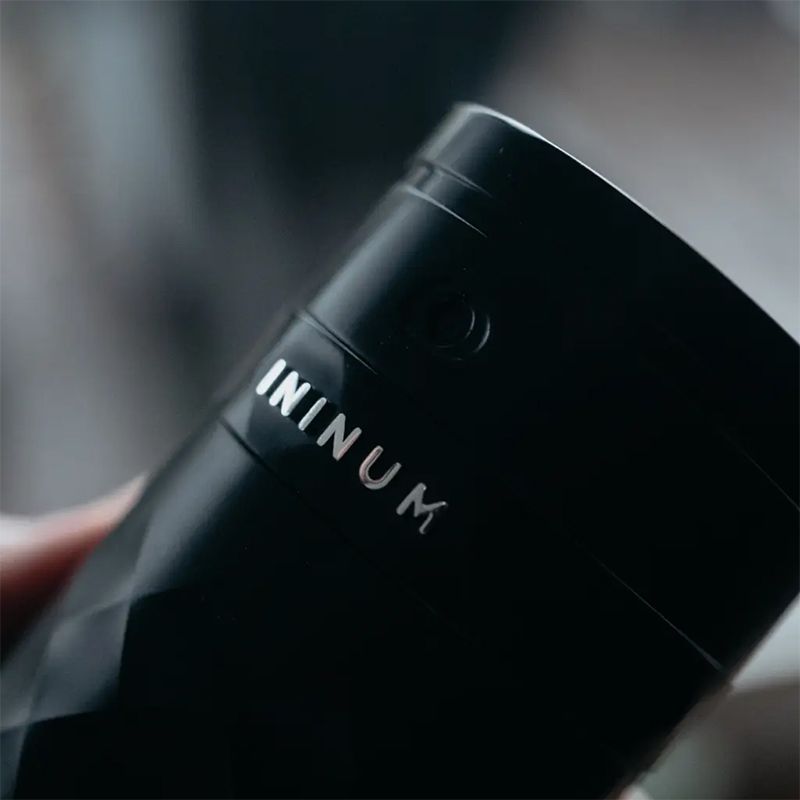 Ininum smart fragrance device by Berlin Packaging Beauty, close-up of faceted black surface with engraved logo and integrated design details for a premium fragrance experience.