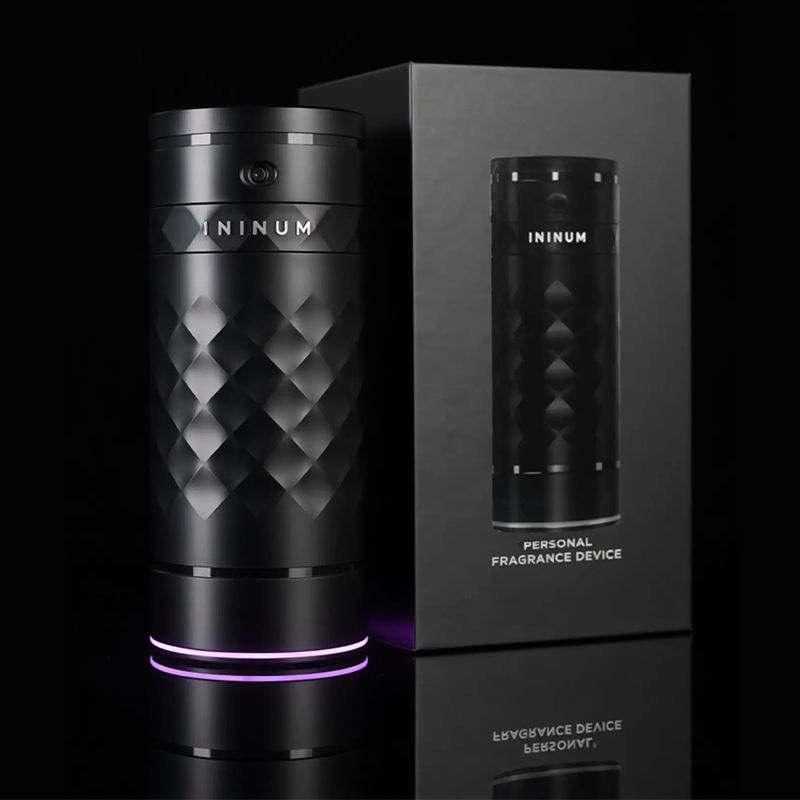 Ininum personal fragrance device by Berlin Packaging Beauty displayed with secondary packaging, featuring a faceted black design, illuminated base and premium unboxing experience.
