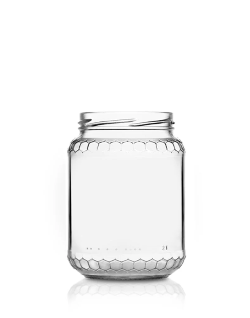 Clear glass jar with hexagonal pattern, empty, on a white background.