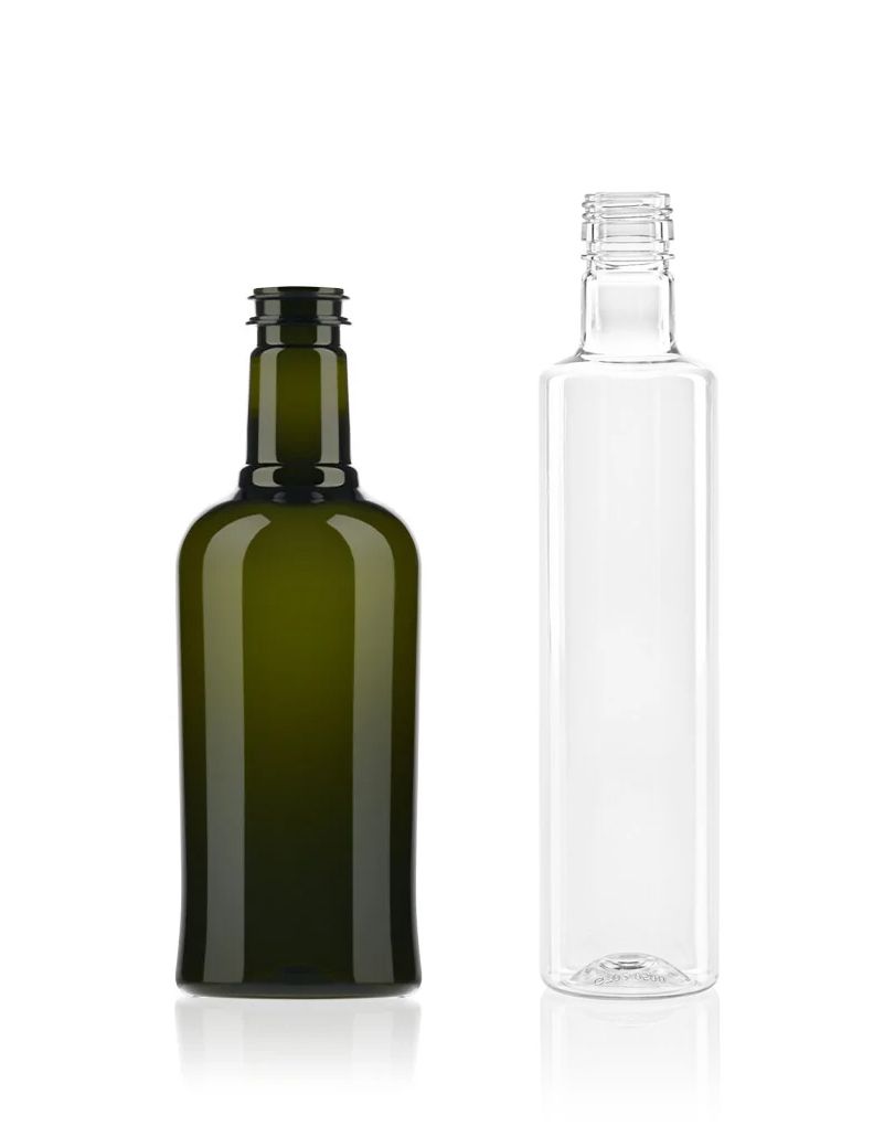 Two empty bottles side by side; one green glass, the other clear. Both have threaded necks and reflections on a white background.