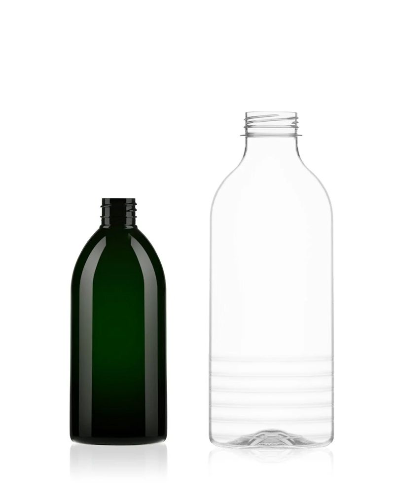 A dark green bottle next to a clear plastic bottle, both without caps, against a white background.