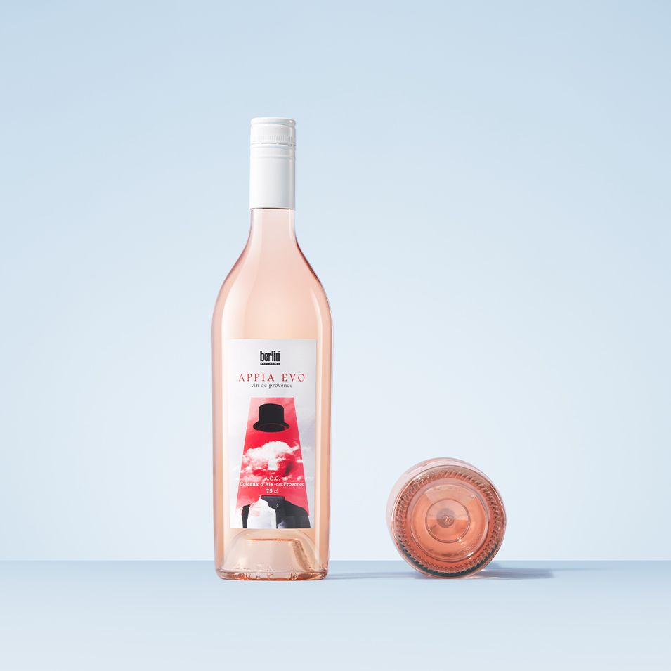 Two Appia Evo bottles by Berlin Packaging with rosé wine, one upright and one lying down, against a light blue background. The label reads "Appia Evo."