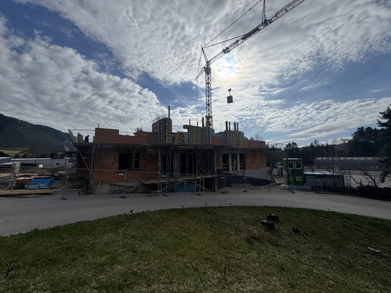 Bauarbeiten am Lebensbogen-Neubau mit Kran und aufsteigendem Mauerwerk in Grünbach am Schneeberg