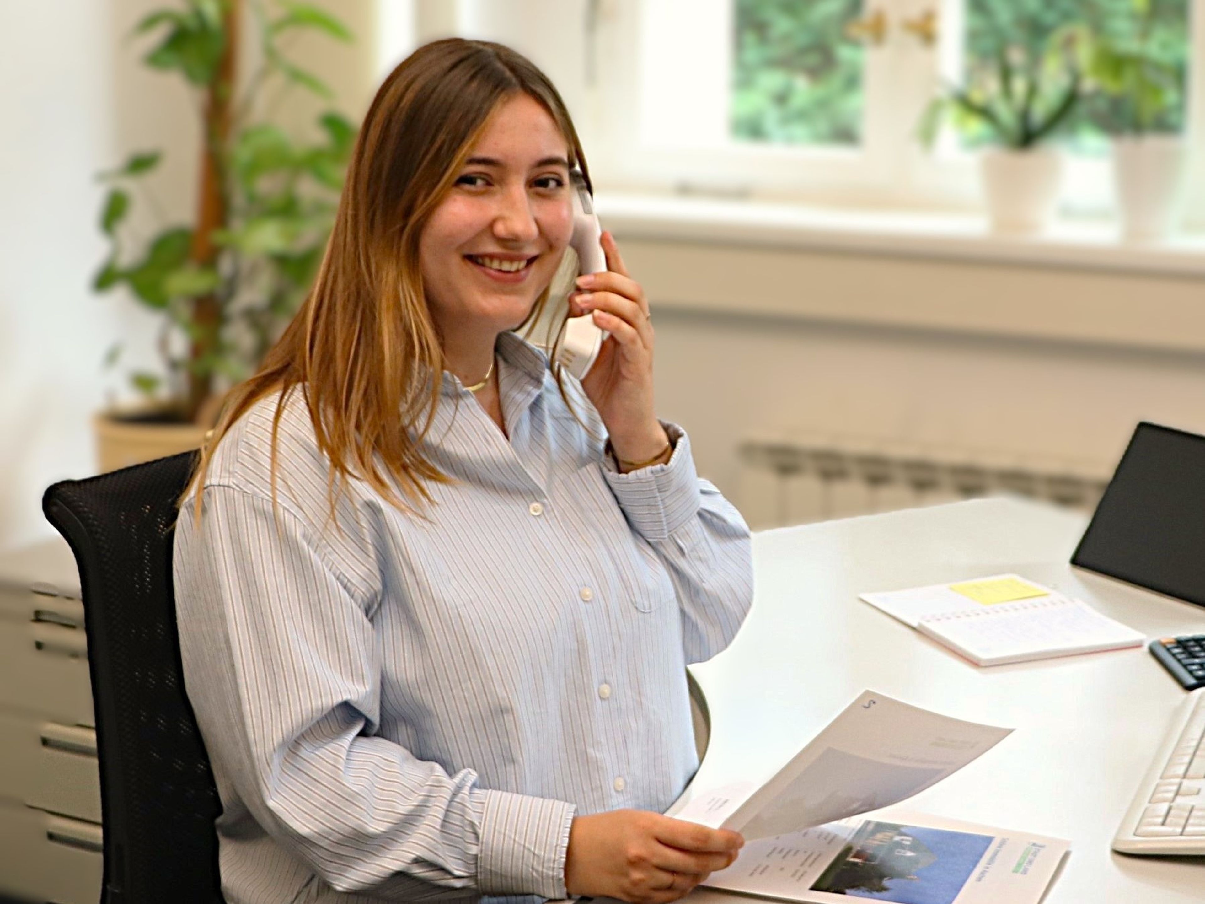 eine Frau telefoniert und schaut in die Kamera