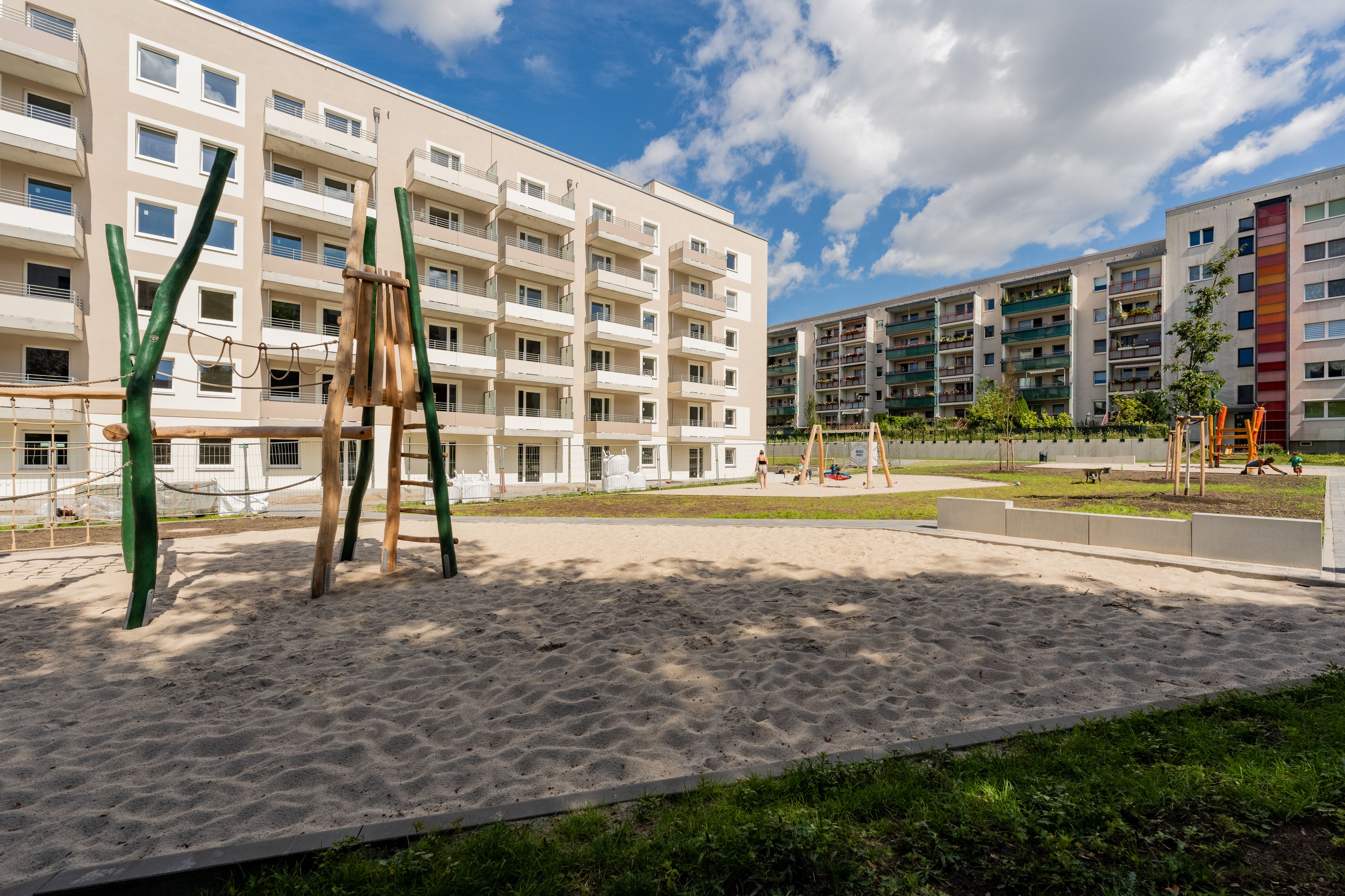 Das Foto zeigt den Innenhof. Darauf befindet sich ein Spielplatz mit einem Sandkasten.
