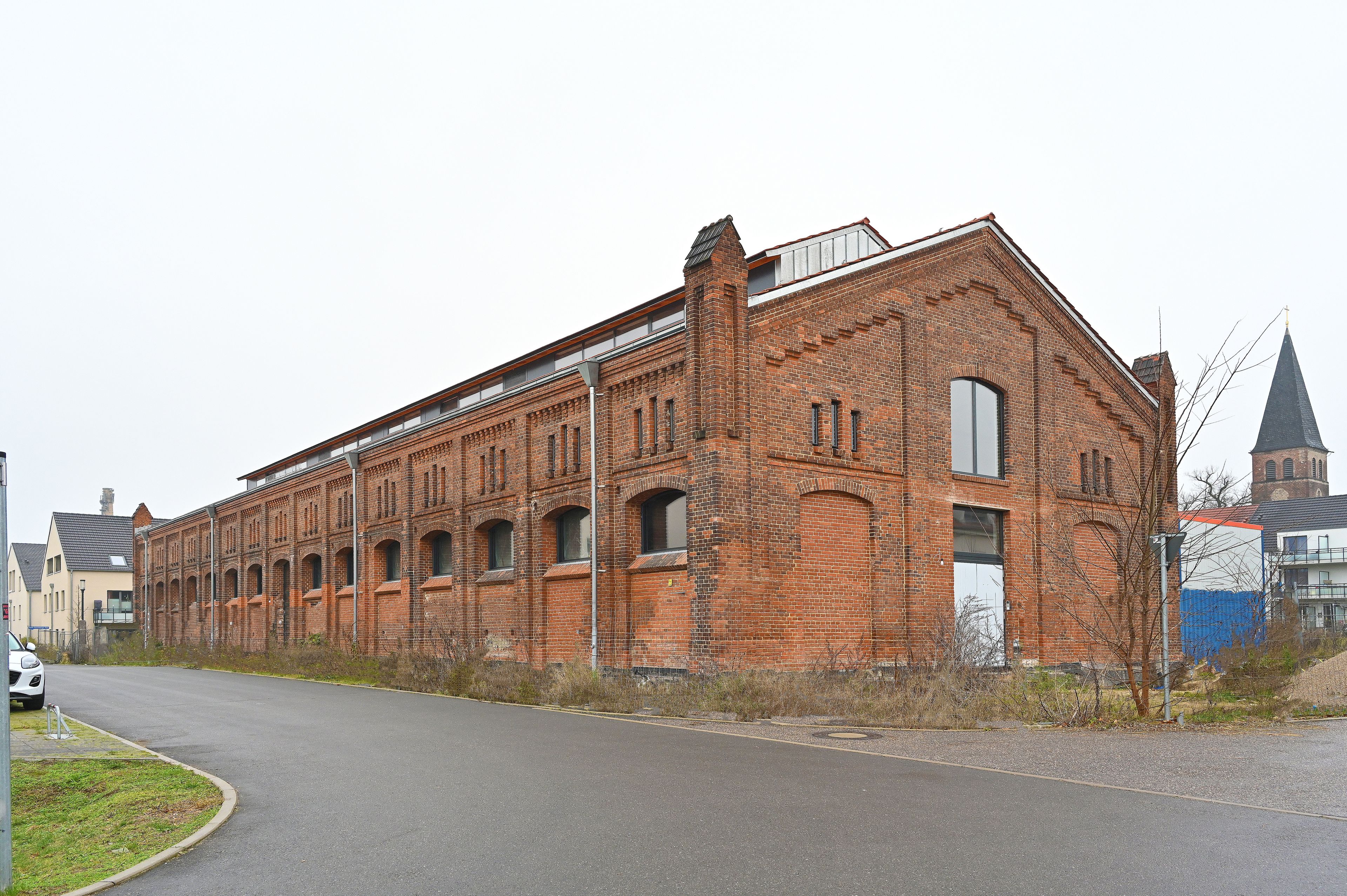 Zu sehen ist ein altes saniertes Gutshaus von der Seite mit roten Backsteinen.