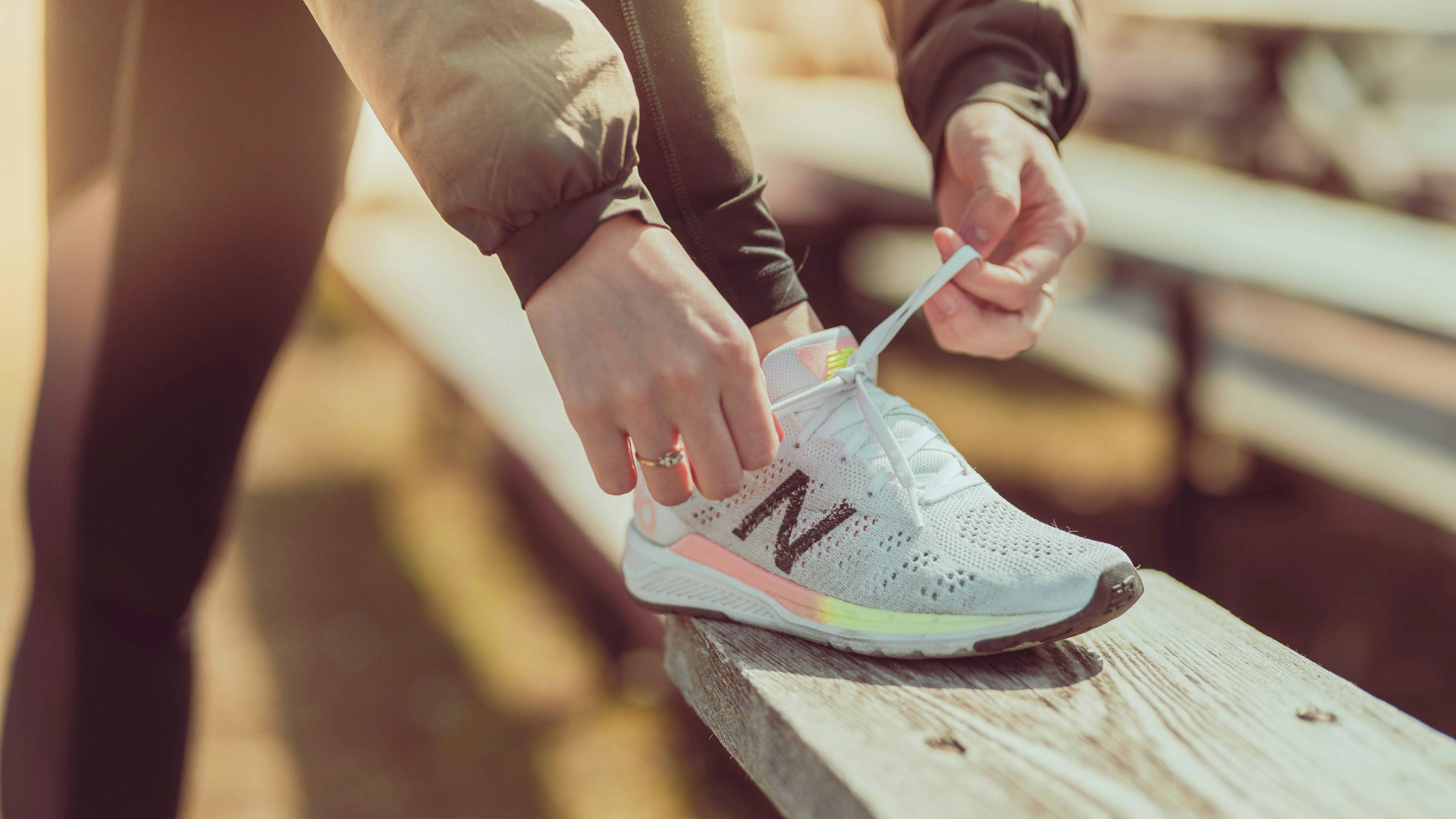 Nahaufnahme einer Läuferin, die sich die Schnürsenkel ihrer Laufschuhe bindet.