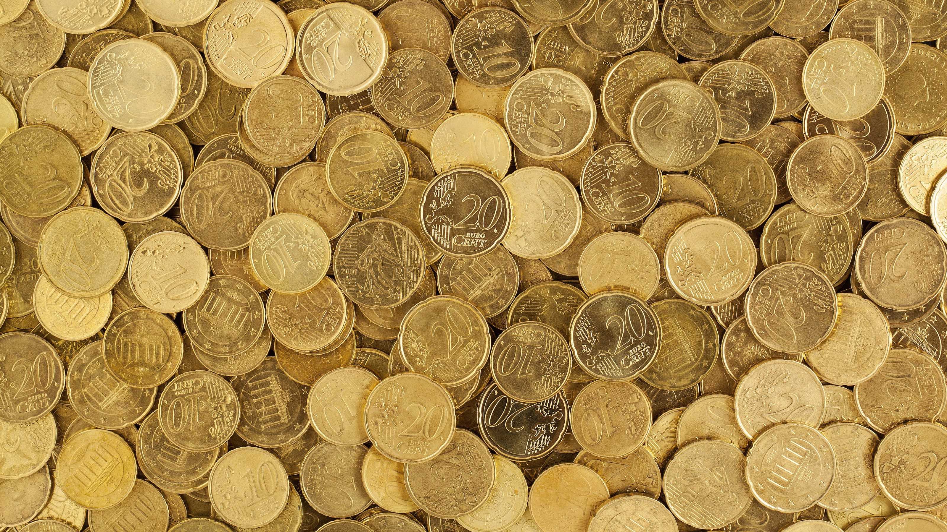 Eine große Menge an messingfarbenen Eurocent-Münzen mit einem Wert von 10 und 20 Cent.