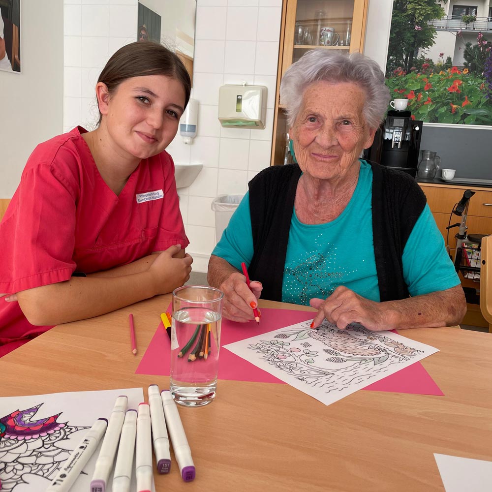 Pflegelehrling Natalie malt mit einer Bewohnerin