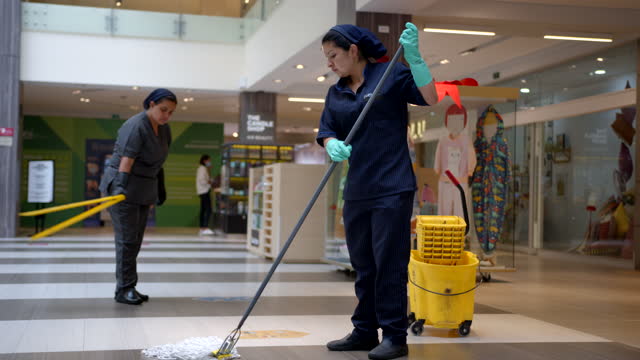 Woman is cleaning the floor with a mop