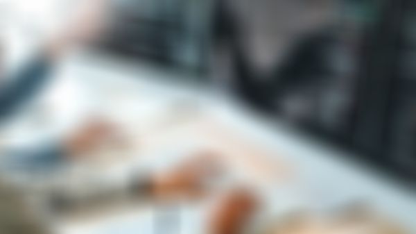 Zwei Personen arbeiten an Computern, auf denen Code angezeigt wird.