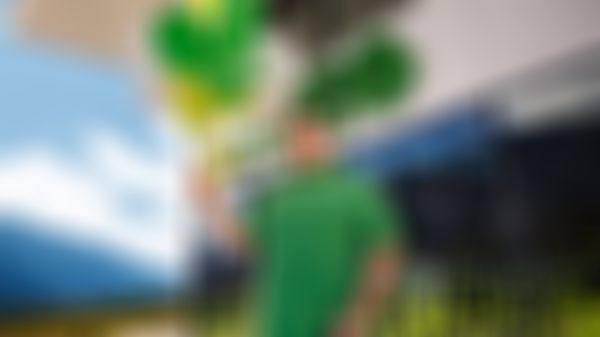 Konstantin Reyer vor einem ADEG Geschäft mit Luftballons in der Hand