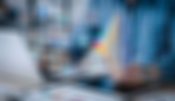 Person, die einen Laptop und ein Tablet mit digitalen Grafiken und KI-Symbolen verwendet, die für Datenanalyse und künstliche Intelligenz stehen.