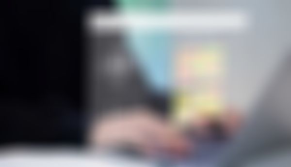 Person, die auf einem Laptop tippt, auf dessen futuristischem Bildschirm eine KI-Schnittstelle und farbenfrohe Bildaufforderungen zu sehen sind.