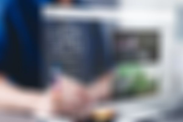 Person, die einen Stylus auf einer digitalen Schnittstelle verwendet, auf der KI-Grafiken und Bilder angezeigt werden, und an einem Schreibtisch mit einem Laptop sitzt.