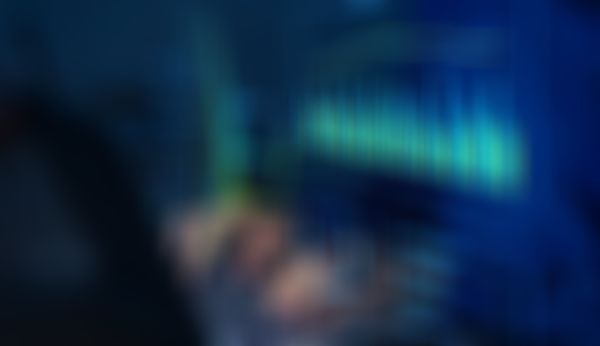 Person, die auf einem Laptop tippt, wobei digitale Datenvisualisierungen, darunter Grafiken und Diagramme, über der Tastatur projiziert werden.