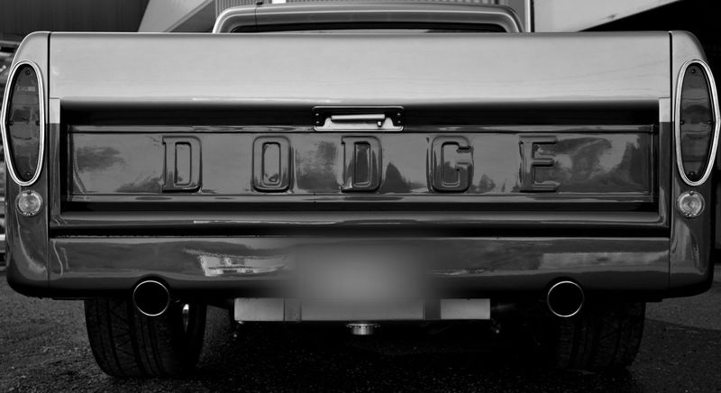 fotografía en blanco y negro de la parte trasera de una camioneta Dodge, la foto fue anonimizada eliminando las placas de matrícula
