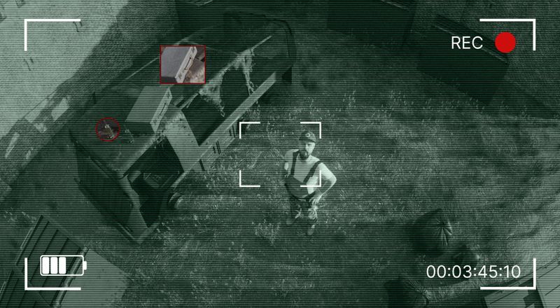 foto de vigilancia en la que un hombre está en el centro y mira a la cámara, al lado hay dos objetos marcados en rojo