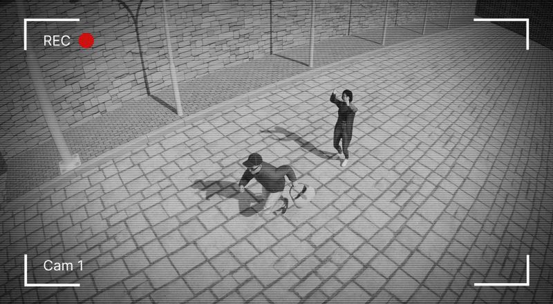 Images de vidéosurveillance montrant deux personnes dans une rue pavée. L'une est accroupie avec un sac, tandis que l'autre se tient debout les bras levés près d'un mur de pierre.