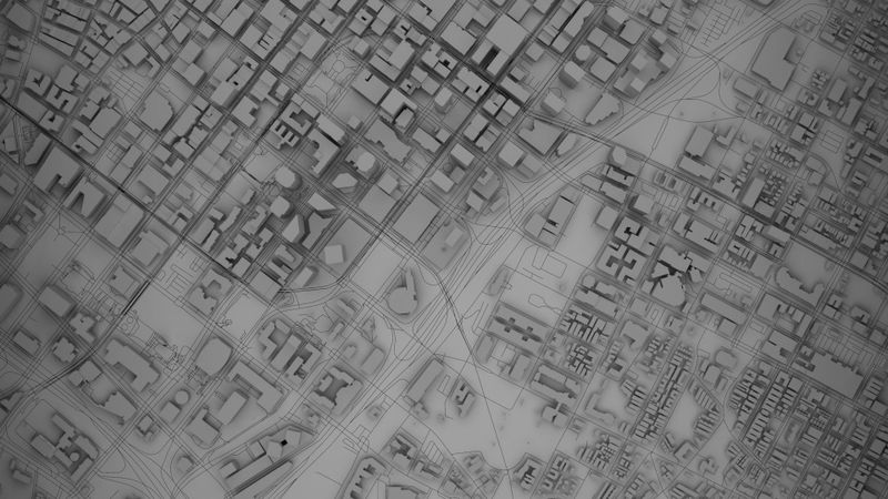 Vista aérea de un mapa detallado de la ciudad en escala de grises con carreteras, edificios e intersecciones, que muestra un diseño urbano.
