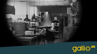 Una persona llevando una bandeja en una cocina comercial con iluminación industrial. La imagen está parcialmente cubierta y tiene la marca "gallio PRO".