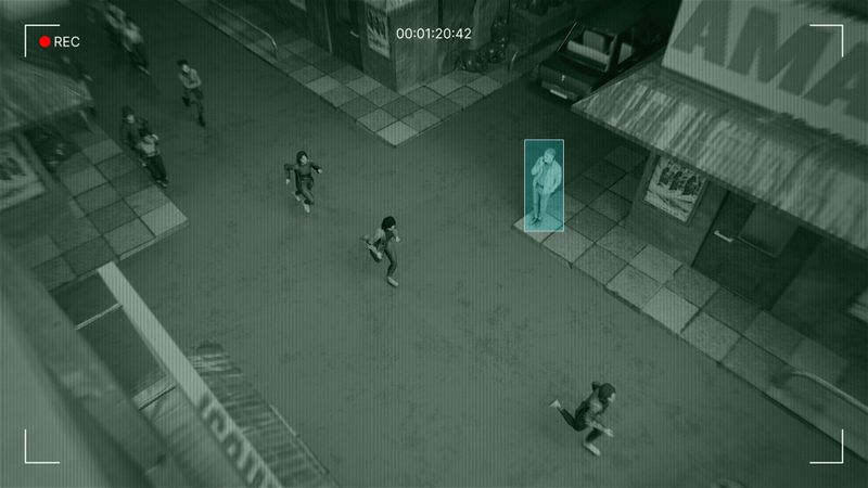 Luftaufnahme einer Straße mit Menschen, die gehen. Eine Person ist durch eine Überwachungskamera-Überlagerung blau hervorgehoben.