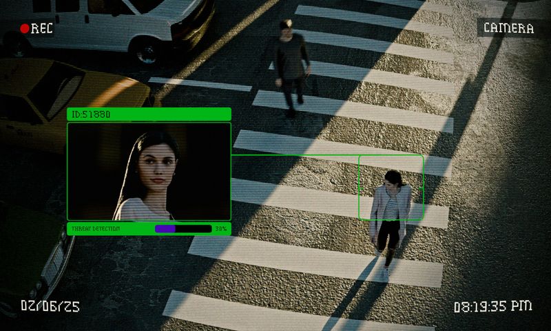foto de vigilancia urbana desde arriba de personas cruzando la calle, en la grabación se acercó el rostro de una mujer