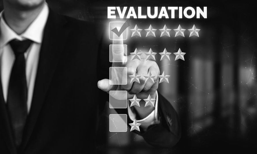 Une personne en costume montre du doigt un système de notation à cinq étoiles sous le mot « Évaluation », la note la plus élevée étant cochée.