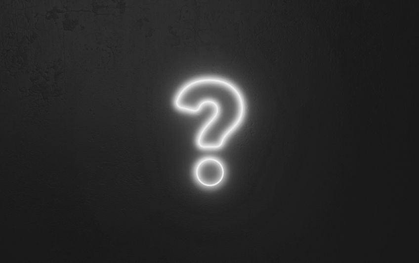 Glowing white question mark on a dark, textured background.