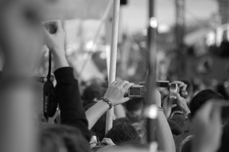 Crowd at an event, holding up cameras and phones to capture the moment, in black and white.