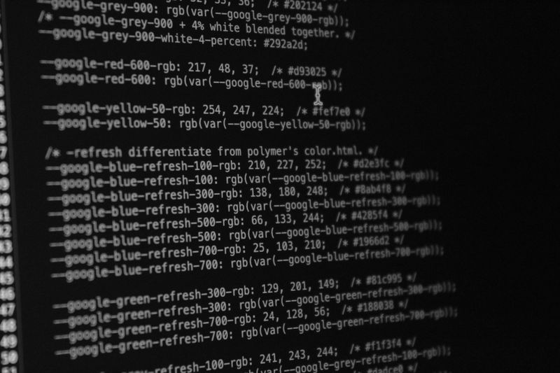 Black and white image of code on a computer screen, showing CSS color variables and RGB values.
