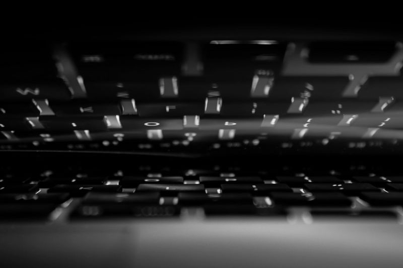 Tapas redondas de plástico blancas y negras dispuestas en forma de signo de interrogación sobre un fondo blanco.