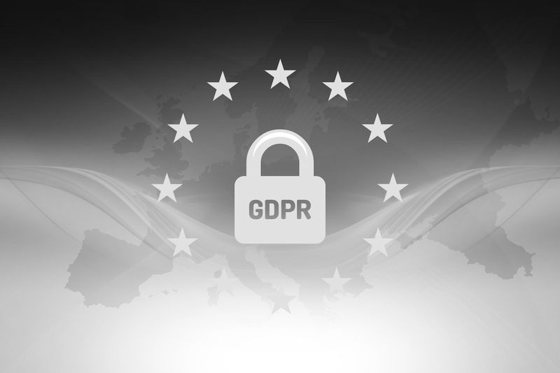 GDPR symbol with a padlock surrounded by stars, set against a grayscale map of Europe background.