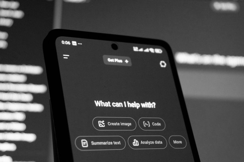 Un ordenador portátil sobre un escritorio blanco con un modelo 3D del cerebro en forma de estructura alámbrica en la pantalla, sobre un fondo gris neutro.