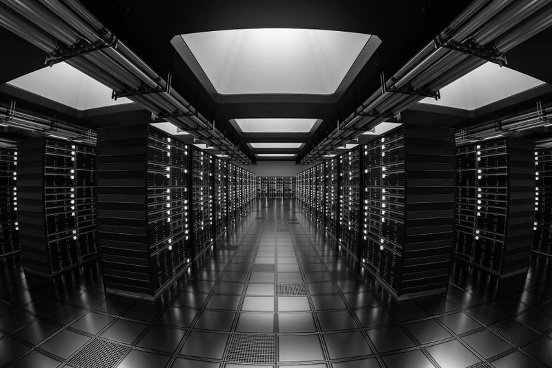 A futuristic, symmetrical data center with rows of servers, illuminated by overhead lights, reflecting on the shiny floor.